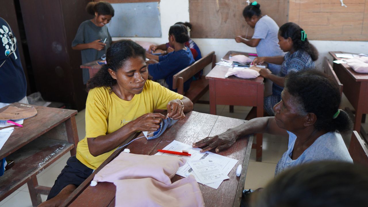 Papuan women engaging in a community sewing workshop, fostering skills and empowerment.